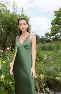 Woman in olive green maxi dress standing in a natural setting