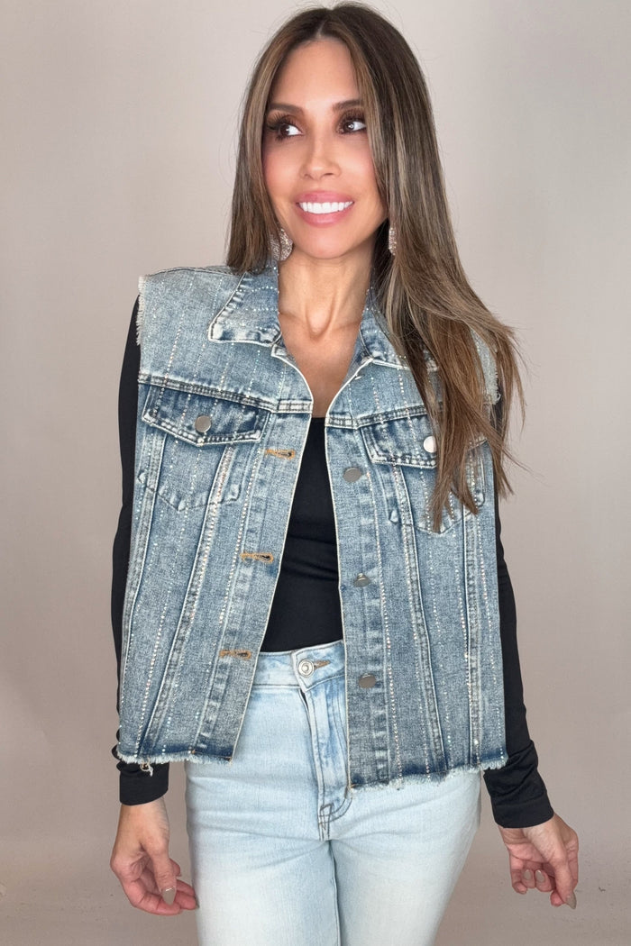 Lightwash blue denim vest with crystal stripe embellishment, metal buttons, chest pockets, and a frayed raw hem.