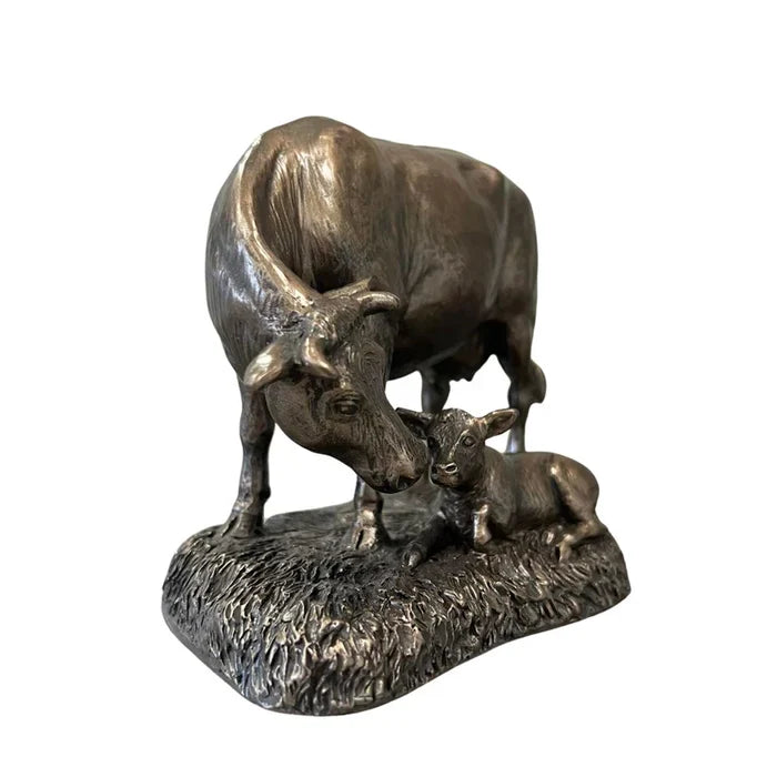 Bronze statue of a bull and calf on a white background
