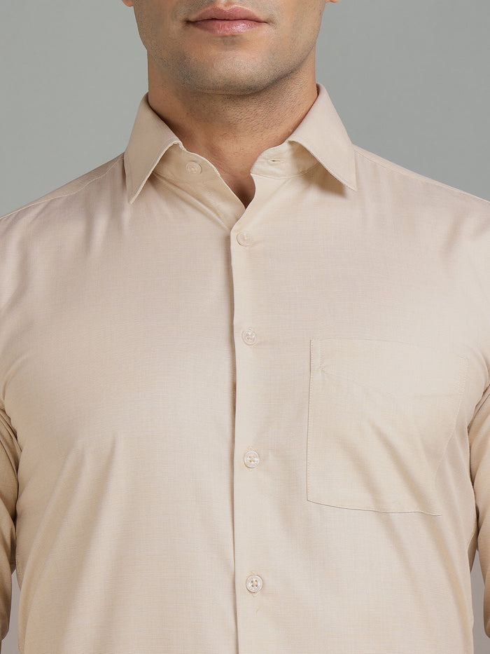 Beige shirt worn by a person on a gray background