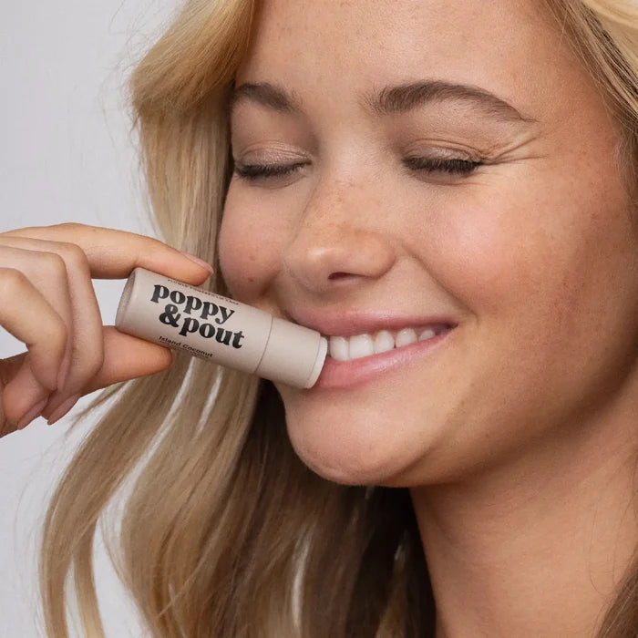 Woman applying a 'poppy & pout' lip balm