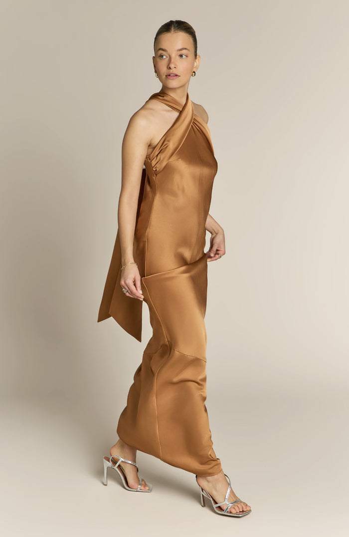 Woman wearing a brown satin dress against a neutral background